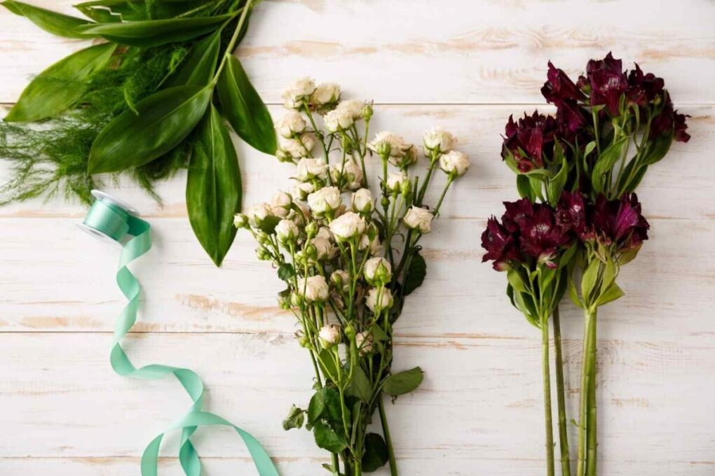 Top view of a beautiful bouquet combining fresh and dry flowers placed on a wooden table.
